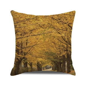 Detail of square pillowcase with autumn forest path print and warm yellow ginkgo leaves