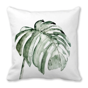 Detail of a tropical monstera leaf print on a white decorative throw pillow case