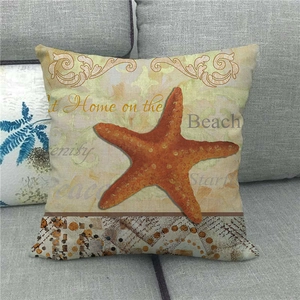 Detail of starfish pillowcase with Beach text on linen fabric and grey sofa