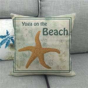 Macro shot of cotton linen sea star pillow with Yoga on the Beach text on sofa