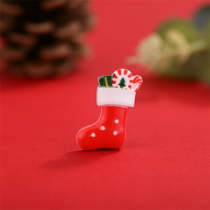 Macro-opname van mini-kerstsok van hars met rode stippen voor DIY-sieradenaccessoires