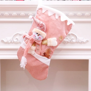 Pink Christmas stocking with 3D snowman and gold sequins hanging on white fireplace