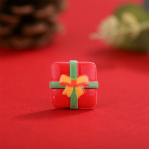 Macro-opname van een rode kerstcadeau-bedel van hars voor DIY-knutselaccessoires