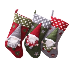 Three large Christmas stockings with gnome dolls and snowflake details on white background