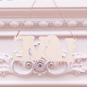 Detail of wooden LOVE cutout sign with gnome silhouette and hanging rope decoration