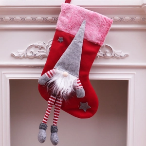 Grande chaussette de Noël en peluche avec gnome et jambes suspendue à une cheminée