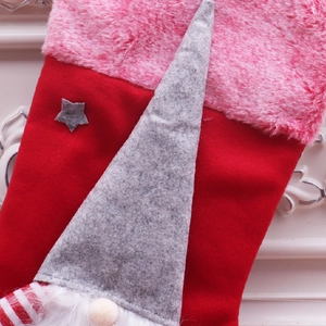 Vue macro de fausse fourrure rose et gnome gris sur une grande chaussette de Noël rouge