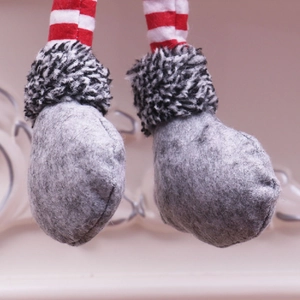 Détail des jambes de gnome en peluche à rayures rouges et blanches avec bordure en fourrure