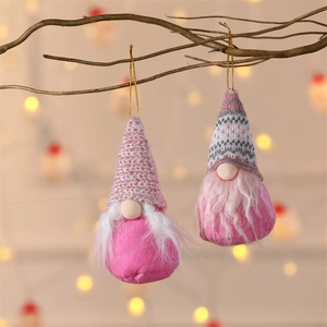 Detail of pink Christmas gnome ornaments with glitter hats hanging on winter branches