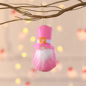 Detailed view of handmade pink felt Christmas gnome ornament hanging on a rustic branch