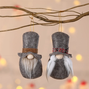 Set of grey Christmas gnomes with plush hats and braids hanging on a wooden branch