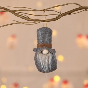 Detail of grey felt Christmas gnome ornament with white beard on branch