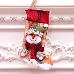 Christmas stocking with snowman 3D design and red plaid trim on white wall background