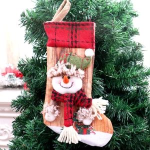 Detailed view of 3D snowman Christmas stocking with plaid scarf hanging on a festive tree