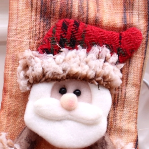 Detail of Christmas stocking featuring Santa Claus with red plaid hat and soft faux fur