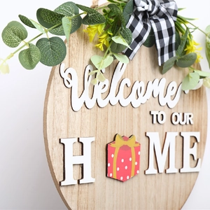 Détail d'une plaque de bienvenue en bois avec lettrage 3D, eucalyptus et nœud à carreaux