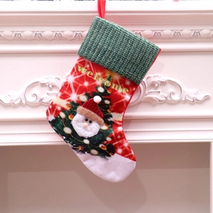 Close-up of LED Christmas stocking with Santa and Welcome text on cozy fireplace