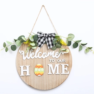 Détail de plaque de bienvenue en bois avec feuilles d'eucalyptus et nœud en tissu