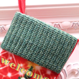 Close-up of knit texture and festive Welcome print on a large LED Christmas stocking