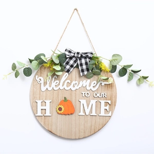 Détail d'une plaque de bienvenue en bois avec nœud à carreaux et motif citrouille