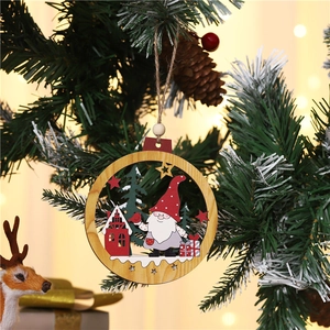 Close-up of laser-cut wooden Santa ornament with hemp rope hanging on a Christmas tree