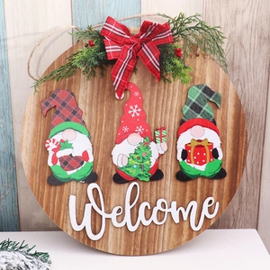 Detail of wooden Christmas door sign with gnomes, 3D welcome text, and festive bow decor
