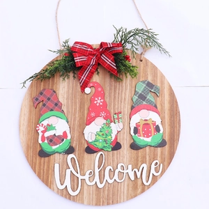 Detail of Christmas wooden welcome sign with gnome characters and pine needle accents