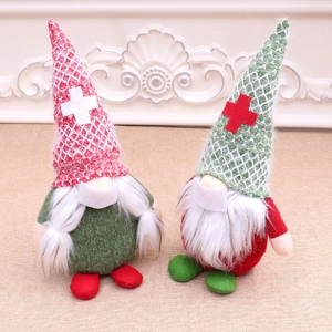 Close-up of two Christmas gnomes with masks in red and green festive knitted hats