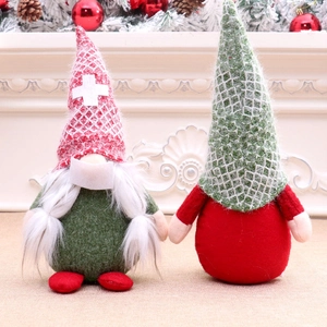 Christmas faceless gnome plush dolls in green and red festive knitwear on a mantel