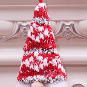 Dettaglio del cappello da gnomo di Natale lavorato a maglia rossa e bianca con cordino