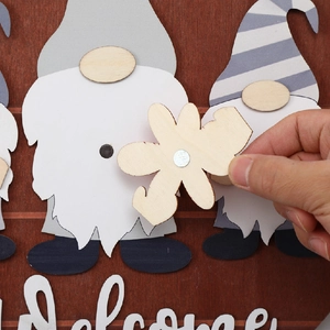 Close-up of interchangeable magnetic wooden gnome welcome sign with floral accessory