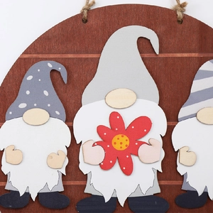 Detail of wooden welcome sign featuring three textured Nordic gnomes with gray pointed hats