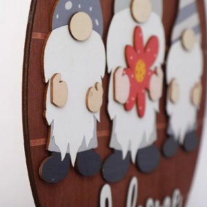 Detail of 3D wooden gnomes with colorful hats and Welcome text on a round door sign