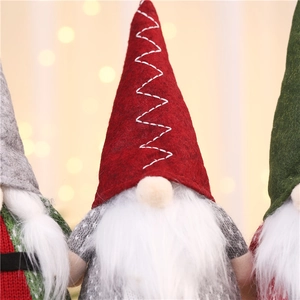 Close-up of three festive Christmas gnomes with glowing lights and soft felt hats