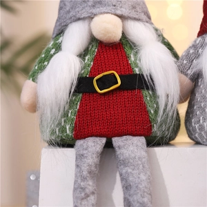 Close-up of a Christmas gnome plush with a green knit sweater and a red festive belt