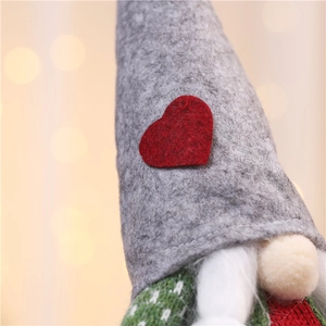 Close-up of a Christmas gnome featuring a felt hat with a red heart and white faux fur beard