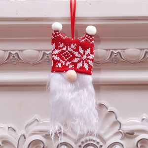 Christmas gnome ornament with red snowflake knit hat and white beard hanging on a fireplace