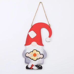Detail view of a Nordic wooden gnome ornament with red hat and sunflower for holiday decor