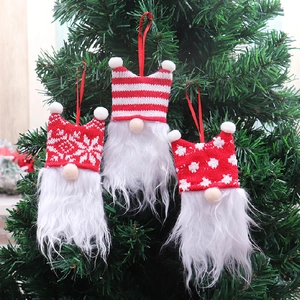 Three-piece Christmas gnome ornaments with red and white knit hats on a Xmas tree