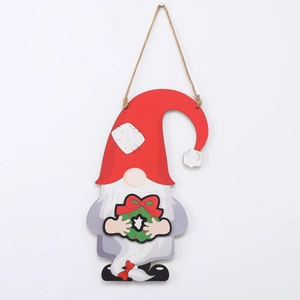 Close-up of a Christmas gnome wood pendant with a red hat and green festive wreath