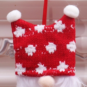 Macro detail of Christmas gnome ornament with red and white snowflake knit patterns