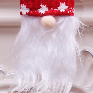 Close-up of Christmas gnome pendant with red snowflake knit hat and white faux fur beard