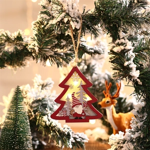 Lighted wooden Christmas tree pendant with gnome design and warm LED glow on snowy pine branch