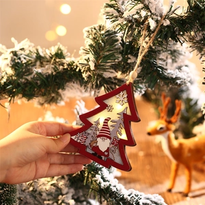 Close-up of lighted red wooden Christmas tree ornament with gnome and warm LED glow