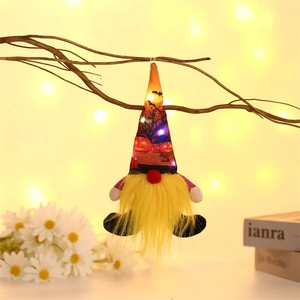 Macro shot of Halloween glowing gnome with LED lights hanging on a rustic branch