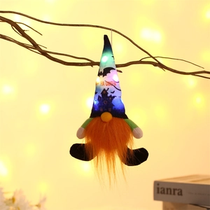 Hanging Halloween glowing gnome with orange beard and LED lights on a branch