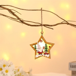 Star-shaped wooden Christmas ornament with glowing scene hanging on a rustic branch