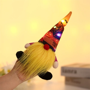 Close-up of a glowing Halloween gnome plush featuring LED lights and pumpkin pattern