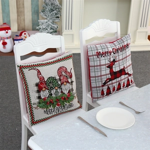 Detail of Christmas gnomes and reindeer embroidered pillow covers on a white chair