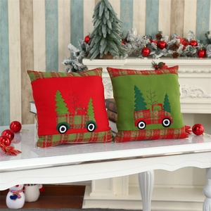 Close-up of velvet Christmas cushion covers with truck and pine tree embroidery detail